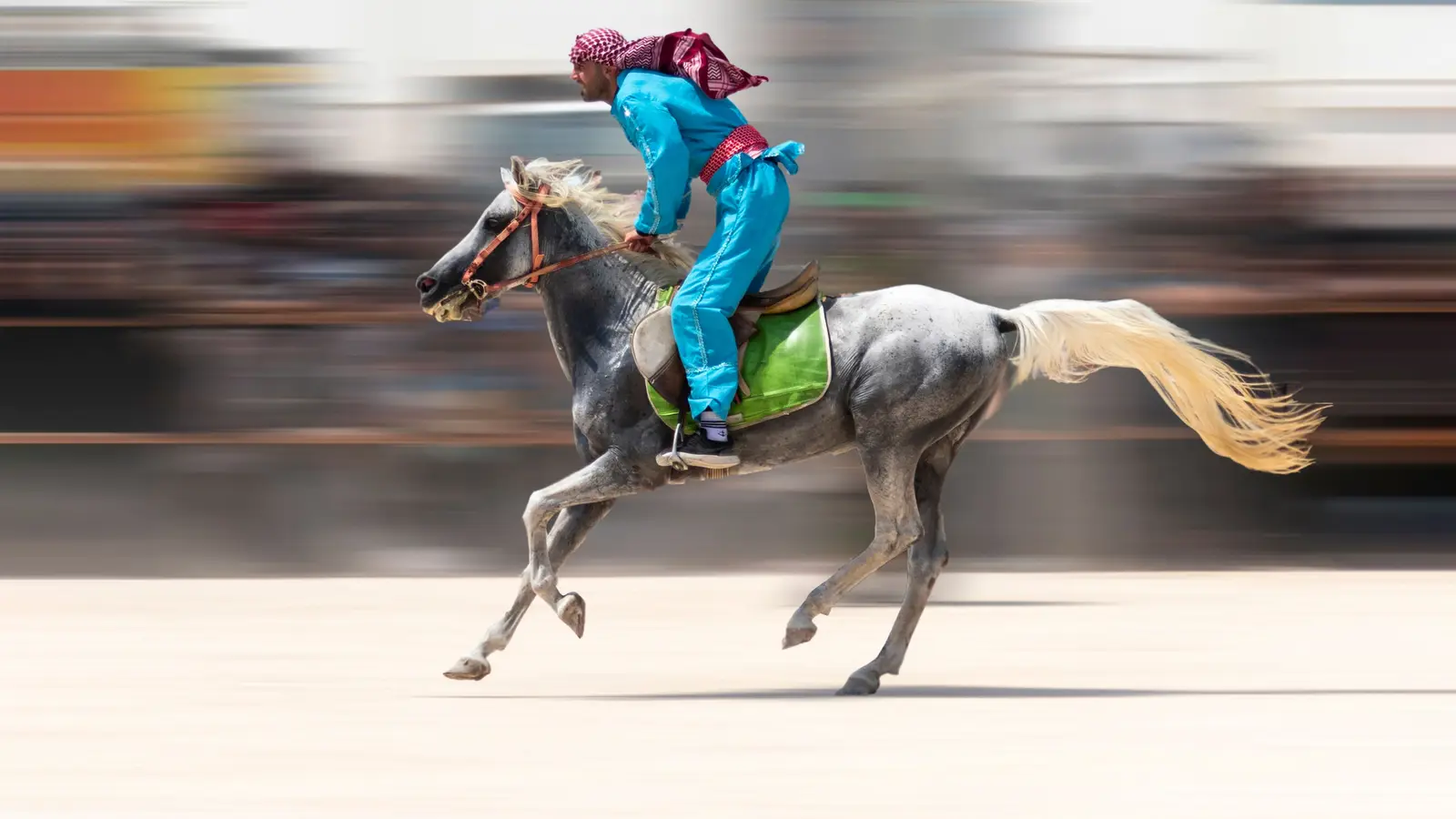A rider on a galloping horse, motion blurred at speed