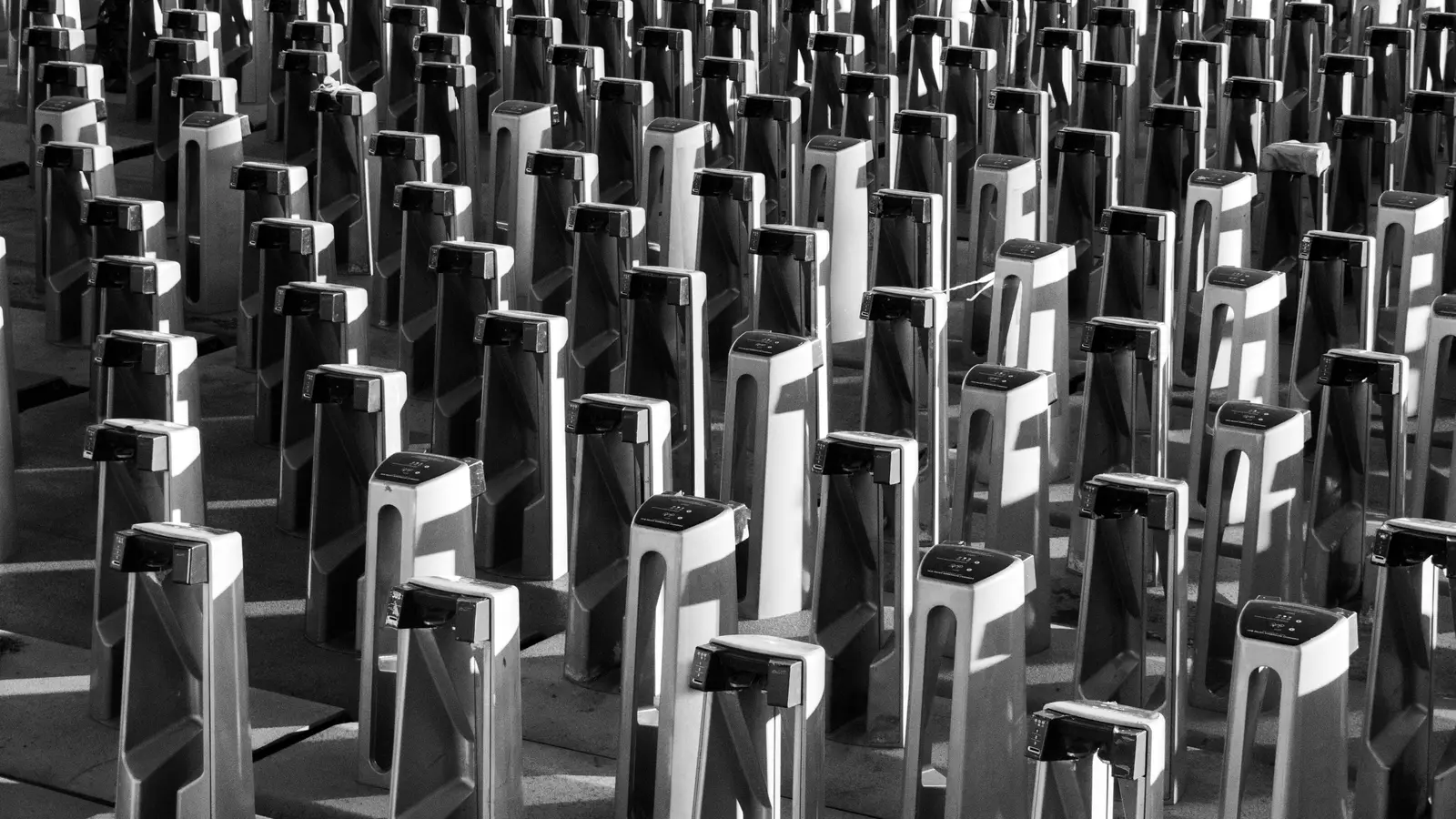 Rows of identical turnstile gates, black and white