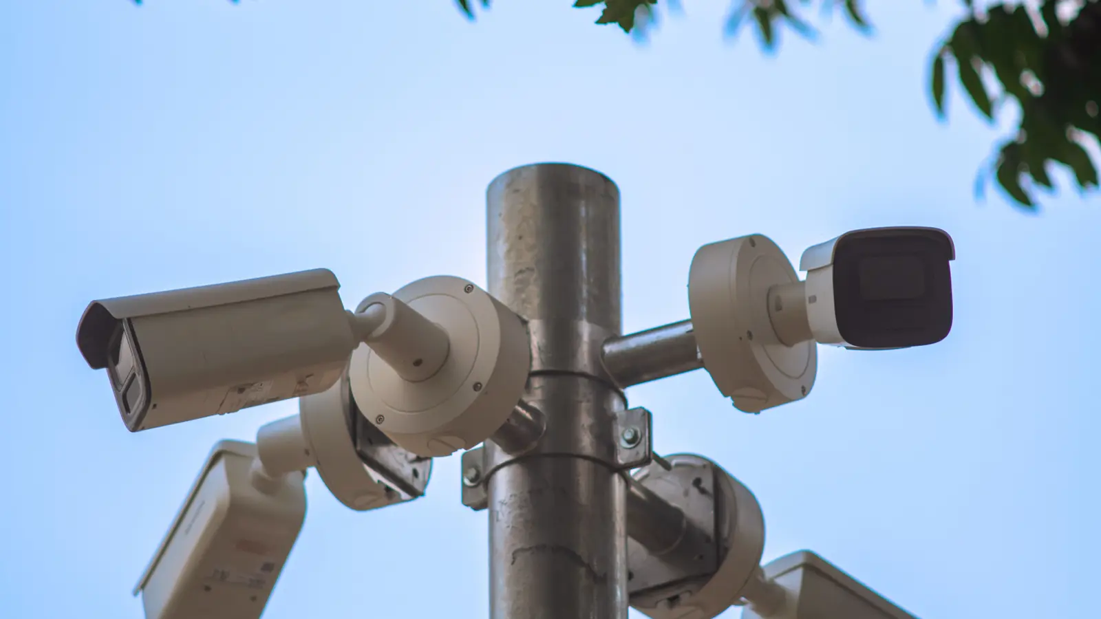 Surveillance cameras mounted on a pole against a clear sky
